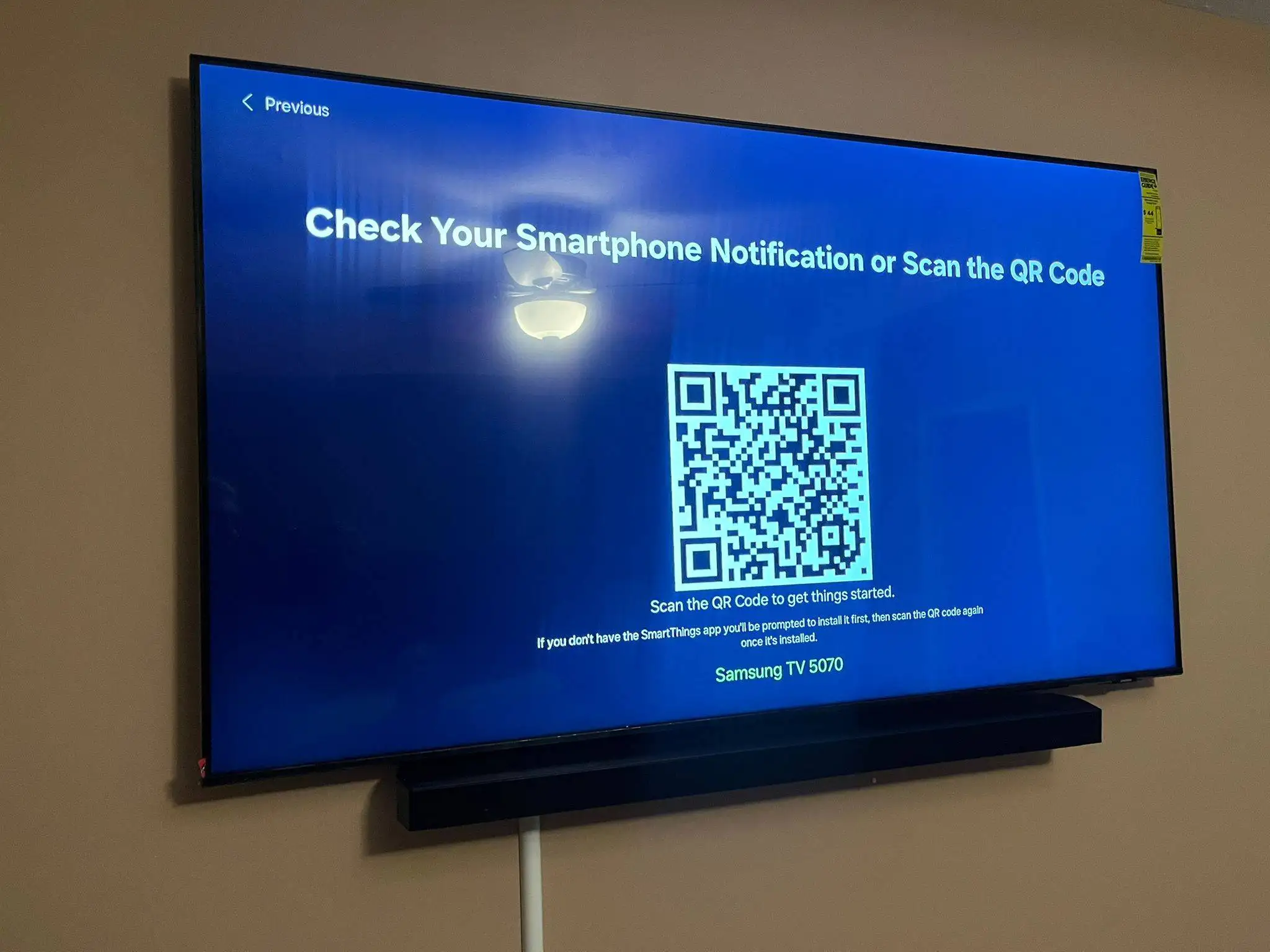 Wall-mounted Samsung TV with a sound bar during first-time setup