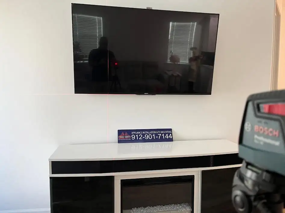 Wall-mounted TV with a black-and-white table underneath it